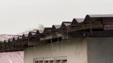 Metal çatılı yağmur fırtınası, çatıdan aşağı akan yağmur suyu.