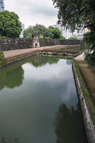 Bulutlu bir günde bir kalenin önündeki bir kanalın dikey fotoğrafı. Santiago Kalesi. Moriones Meydanı. Turist. Bulutlu bir günde bir su kanalının kaleden önceki dikey fotoğrafı. Santiago Kalesi. Moriones Meydanı. Turist.