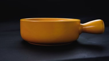 Kızartma tavası şeklinde sarı seramik tabak. Siyah bir arkaplana yerleştir. Foodie!