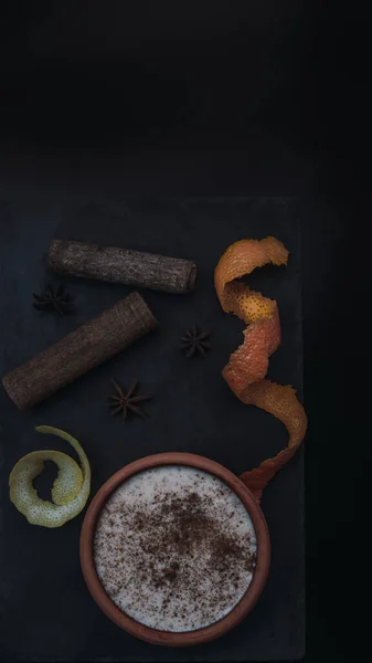 Pirinçli puding, yanında limon, portakal kabuğu ve tarçın çubukları olan bir tabakta servis edilir. Foodie. Üst görünüm