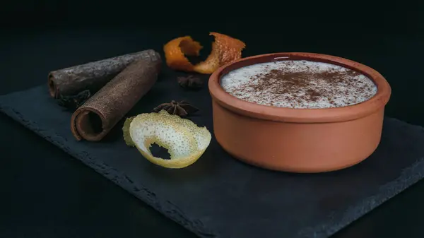 Pirinçli puding, yanında limon, portakal kabuğu ve tarçın çubukları olan bir tabakta servis edilir. Foodie!