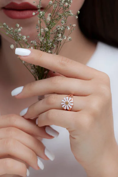 colorful lotus silver paint in well-groomed hands with white nail polish