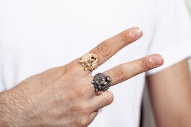 Beyaz tişörtlü genç erkek model gümüş yüzük taşıyor..