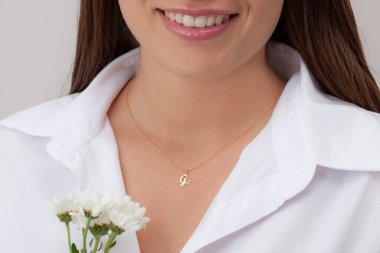 Çekici beyaz elbiseli kızın boynunda altın rengi bir kolye. Kişisel kolye imajı. E- ticaret için mücevher fotoğrafı, online satış, sosyal medya.
