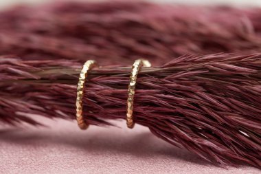 Pembe arka planda küpe resmi. Mücevher yaratıcı ve renkli bir arka planda sergileniyor. E- ticaret için mücevher fotoğrafı, online satış, sosyal medya.
