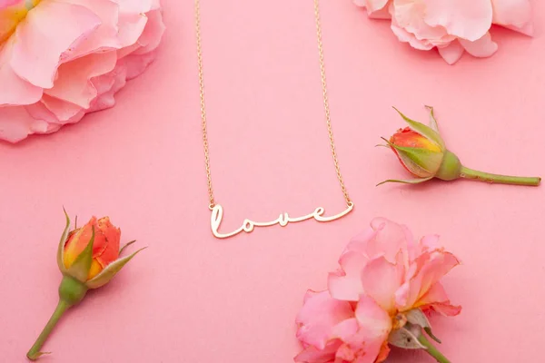 Still life jewelry picture for online sale. Photo of a silver necklace on a pink floral background that we can use in e-commerce, online sales, and social media.