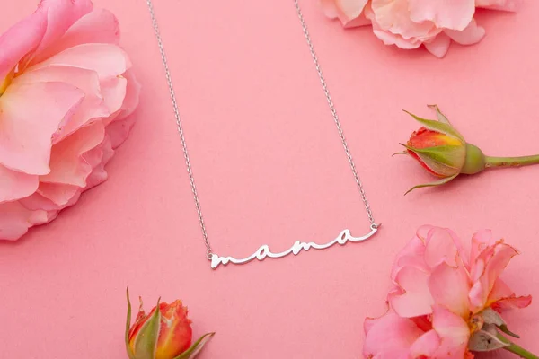 Still life jewelry picture for online sale. Photo of a silver necklace on a pink floral background that we can use in e-commerce, online sales, and social media.