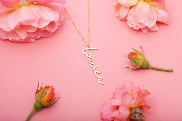 Still life jewelry picture for online sale. Photo of a silver necklace on a pink floral background that we can use in e-commerce, online sales, and social media.