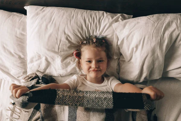귀엽고 귀엽게 소녀가 침대에서 일어나서 스트레칭하는 — 스톡 사진