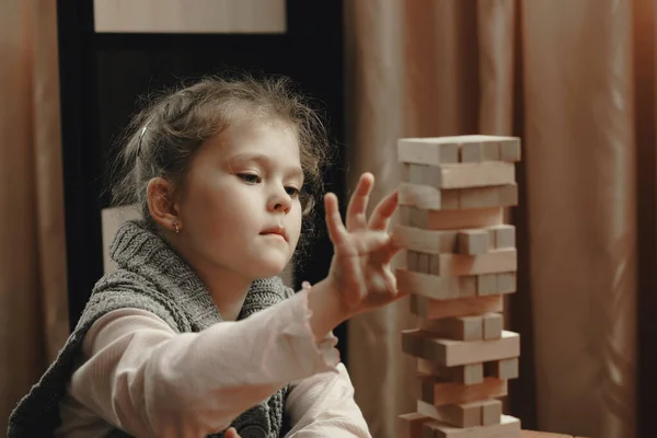 かわいい女の子は木のブロックから塔を構築し ボードゲームをプレイ — ストック写真