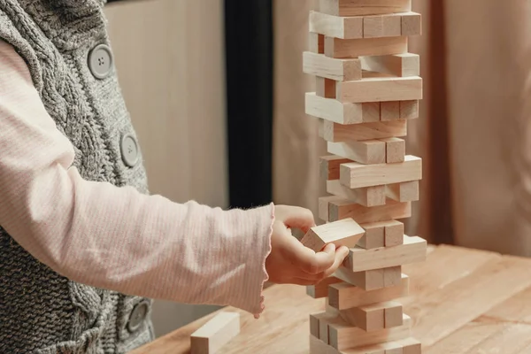 一个玩棋盘游戏的孩子的手 用木块建造了一座塔 — 图库照片