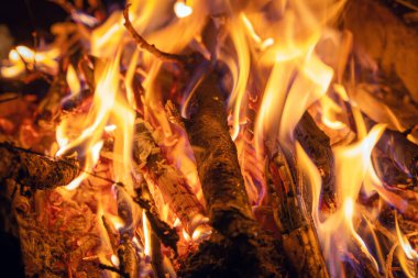 Karanlıkta yanan bir ateşin parlak alevi.