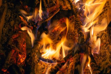 Karanlıkta yanan bir ateşin parlak alevi.