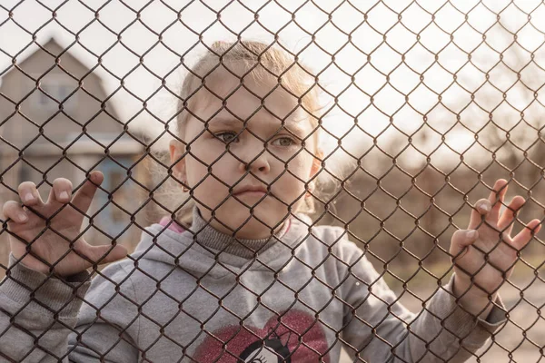 Egy Kislány Szomorú Tekintettel Fémkerítés Mögött Menekültek Kényszermigránsok Társadalmi Problémája — Stock Fotó
