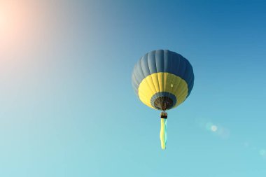 Mavi gökyüzü arka planında Ukrayna bayrağı olan çok renkli sıcak hava balonu.