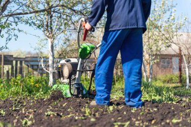 Çiftçi adam ekiciyle toprağı sürüyor toprağı ekime hazırlıyor..
