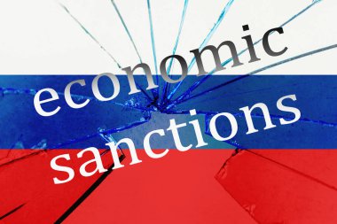 Kırık cam dokusunda Rus bayrağı ve yazılı ekonomik yaptırımlar..