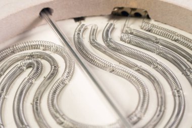 Fırın ısıtma elementinin sarmalına yakın çekim. Ev aletlerinin onarımı ve bakımı.