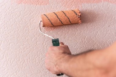 Adamın eli duvarı pembeye boyuyor..