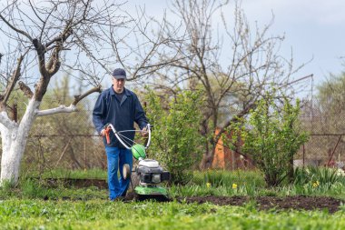 Çiftçi adam ekiciyle toprağı sürüyor toprağı ekime hazırlıyor..