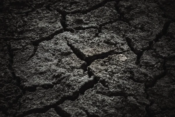 Siyah kurumuş toprak çatlamış toprak, arka plan dokusu.
