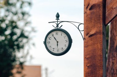 Bir direğe bağlı sokak saati, yakın plan..