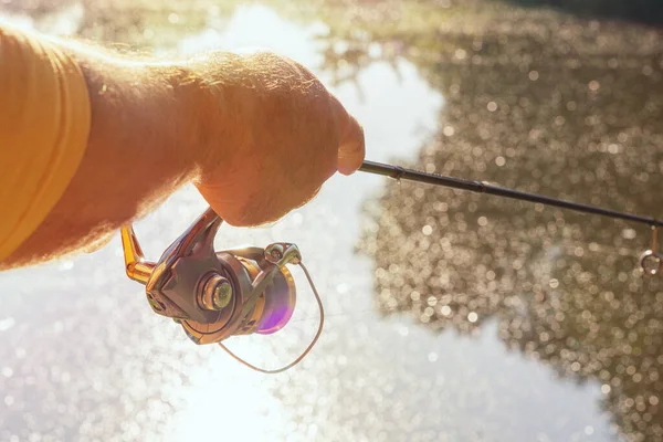 渔夫在河里纺鱼 手里拿着一根钓竿 把钓丝卷了起来 — 图库照片