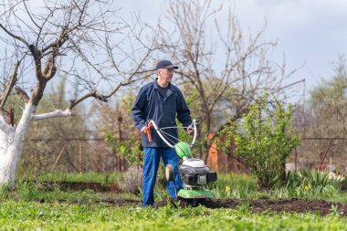 Çiftçi adam ekiciyle toprağı sürüyor toprağı ekime hazırlıyor..