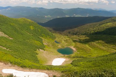 Karpatlar 'ın dağlarında. Dağlar, ilkbaharda, çimenlerin ve ağaçların yeşilinde boğulur. Bazı yerlerde, yüksek rakımlı göllerin suyla doldurulduğu beyaz kar lekeleri bile hâlâ korunur..