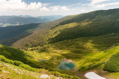 Karpat dağlarının yamaçları, bulutlu gri gökyüzünün arka planına karşı yeşil ve gri renge döner..