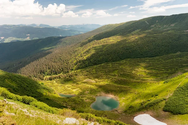 Karpat dağlarının yamaçları, bulutlu gri gökyüzünün arka planına karşı yeşil ve gri renge döner..