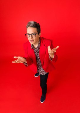 Kendine güvenen bir hippinin yüksek açılı pozu. kırmızı arkaplanda izole