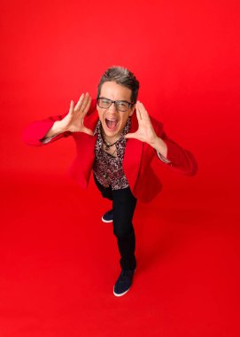 Kameraya avuçlarını gösteren bir adamın mutluluk içinde bağırışının yüksek açılı görüntüsü. kırmızı arkaplanda izole