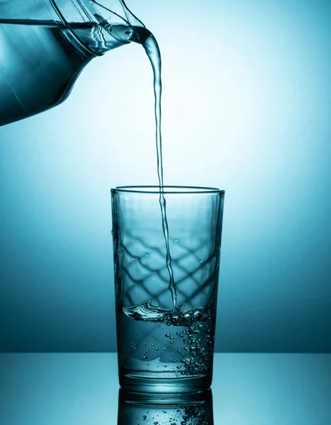 Pouring water from a pitcher into a glass