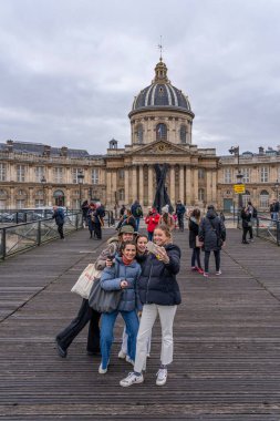 Paris, Fransa - 113 2021: Fransa Enstitüsü ile birlikte Pont des Arts 'ta selfie çeken gülümseyen bir grup genç turist kız görüntüsü