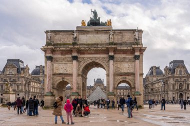 Paris, Fransa - 12 04 2021: Bir grup gülümseyen genç turist kız Atlı Süvari Zafer Kemeri önünde selfie çekiyorlar