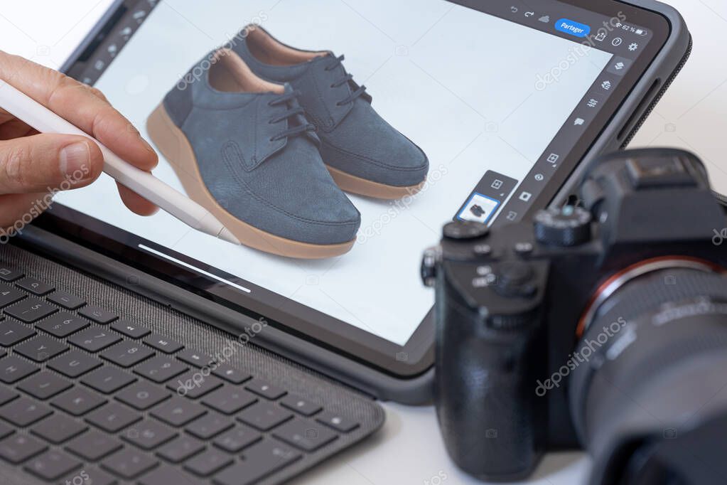 still life. Studio shot detail of a tablet, stylus, keyboard, screen, camera and a pair of men's shoes with blue laces and brown soles