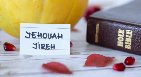 Yehova Jireh, kutsal kitap, balkabağı ve dökülen kırmızı yapraklarla Tanrı 'nın el yazısıyla yazılmış bir ismi. İncil 'deki aşk kavramı. Tanrı 'nın bize sağlayacağı bir Hristiyan inancı. Yakın çekim..