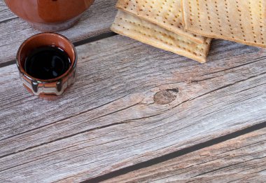 Mayasız ekmek (matzo) ve Hristiyan Hamursuz Bayramı kutlamaları için ahşap bir masada küçük bir bardak şarap. Uzayı kopyala Üst Manzara. İsa 'nın vücudunun ve kanının sembolleri. İncilsel kavram.