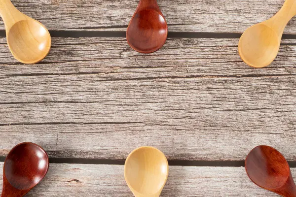 Tahta kaşıklar ahşap arka planda fotokopi alanı ile. Sürdürülebilir yaşam, çevre dostu mutfak aletleri, plastik olmayan ürünlerle yemek ve yemek yapma kavramı. Üst masa manzaralı. Yakın çekim..