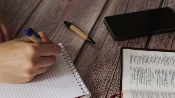 Vrouwelijke Handschrift Een Notitieboekje Een Houten Tafel Met Een Pen — Stockvideo