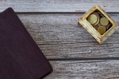 İncil kitabı ve üzerinde altın madeni paralar olan bir kutu. Üst Manzara. İncil 'deki vergiler, bağışlama, sunma, şükran günü, finansal kutsama ve cömertlik kavramları..