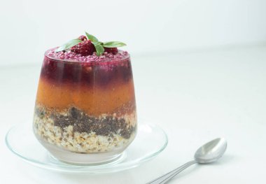 Taze meyve, sebze, yulaf, chia tohumu ve beyaz kaşıkla bir bardakta fındık ile yapılan katmanlı chia pudingi. Yakın çekim..