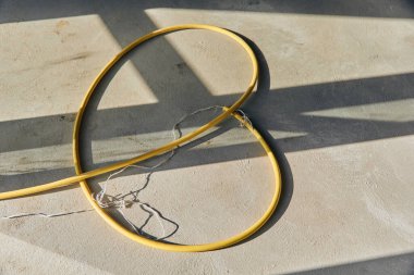 Beton zeminde sarı hortum borusu. 