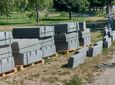 Sınır. Topakların ve çimenlerin üzerinde yığılmış sınırlar. Paletler beton kaldırımlı. Kaldırımın onarımı.