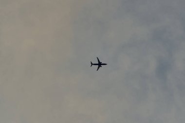 Gökyüzünde uçak ve beyaz bulutlar.