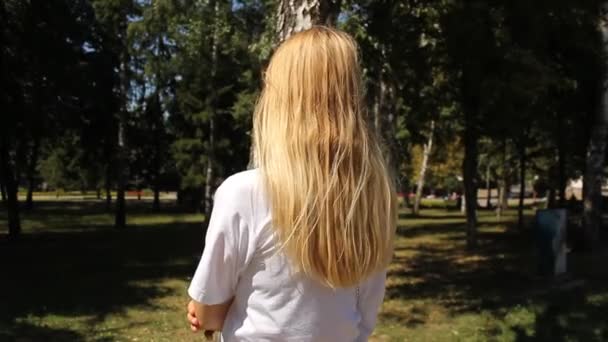 ブロンドの女の子のリアビュー 自然背景 — ストック動画