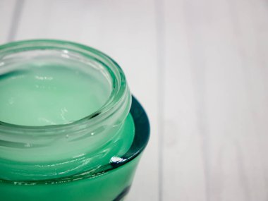 Beyaz arka planda spa ile ilgili bir nesne, yeşil vücut kremi. Vücut ve cilt bakımı düz ve fotokopi alanı var. Güzellik konsepti