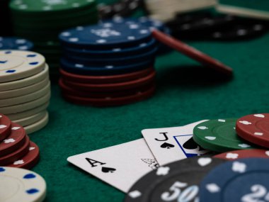 Poker masası, as ve jack blackjack skoru ve yeşil masada bir yığın oyun fişi