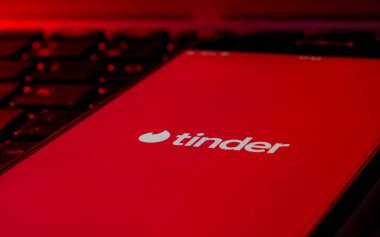 Tinder Randevu uygulaması logosu olan bir bilgisayar klavyesinde akıllı telefon